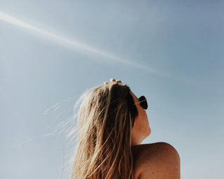 Woman wearing sunglasses, facing the sun